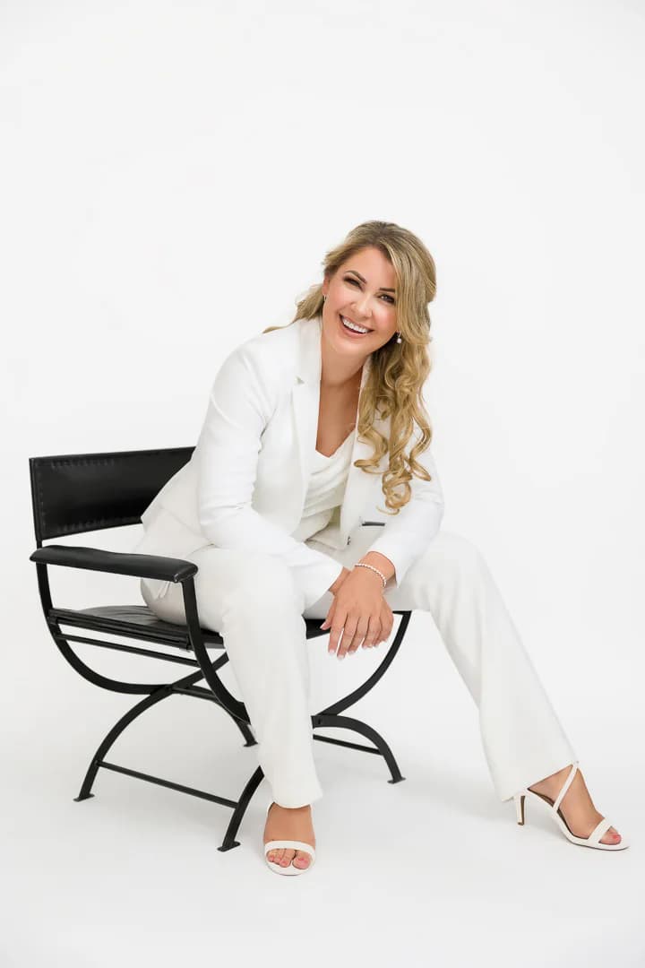 Erin Ashlee Rose smiling in a white suit for a commercial portrait
